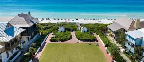 A coastal property with a large lawn, beach access, and multiple buildings.