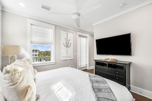 A bedroom with a bed, a TV, a dresser, and a window with blinds. - Serenity by the Sea 30A (Panama City Beach)