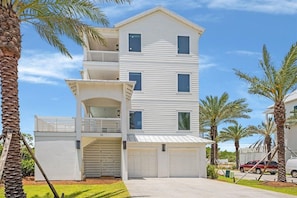 A multi-story residential building with a garage, a balcony, and a driveway. - Amberjack (Panama City Beach)