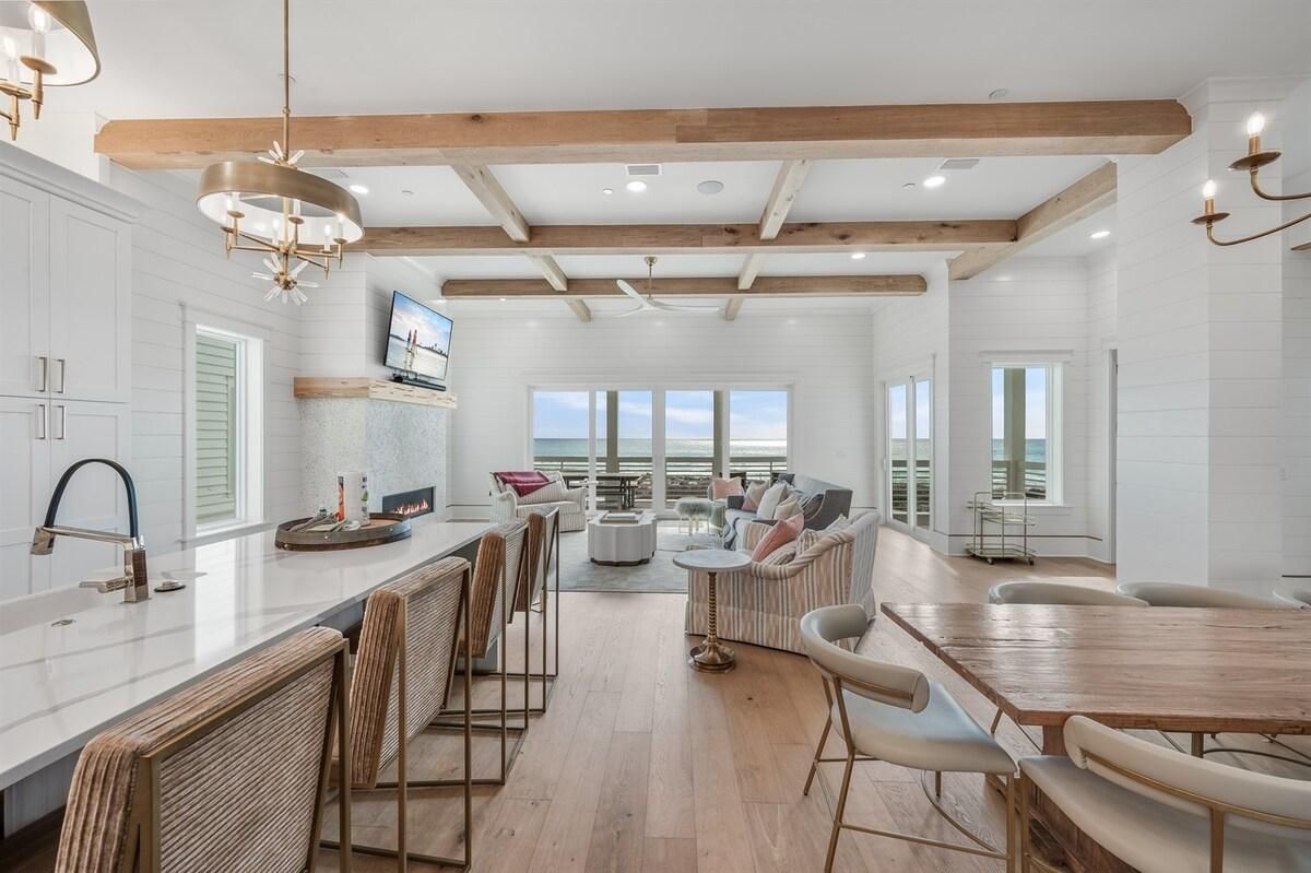 Una cocina amplia con una isla grande, vigas de madera y vistas al exterior.