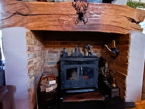 Una chimenea de estilo rústico, con una pared de ladrillo y un fuste de madera.