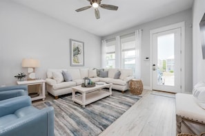 A living room with a white sofa, blue armchairs, a coffee table, and a ceiling fan. - Sea Vous Play (Santa Rosa Beach)
