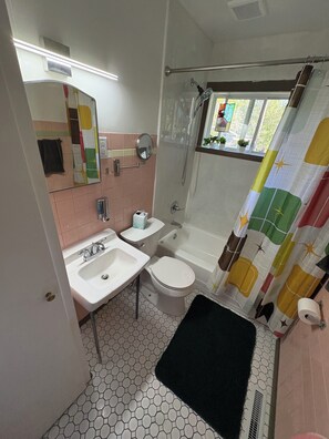 Et badeværelse med vask, toilet og badekar.