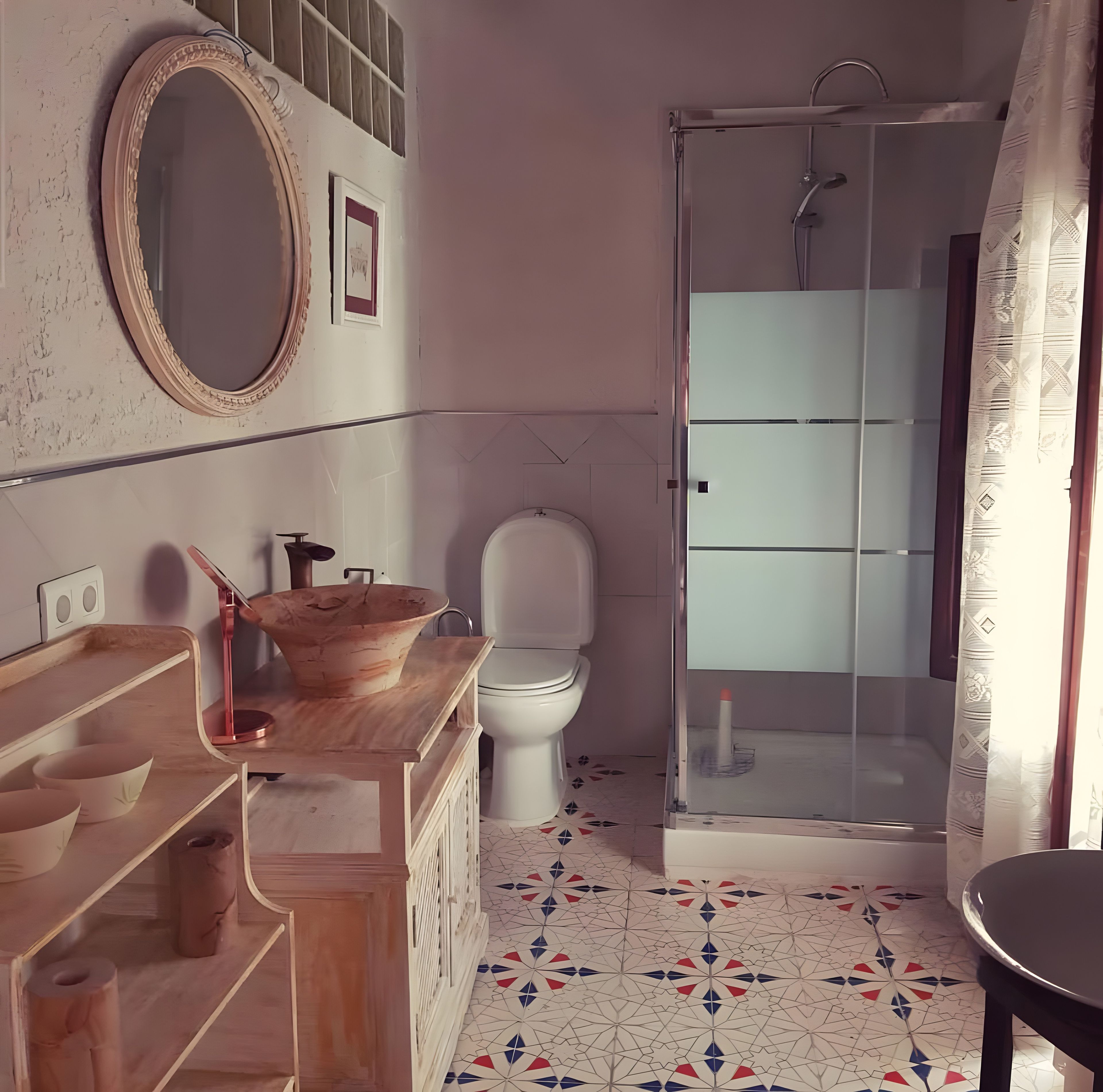 A bathroom with a wooden vanity, a white toilet, and a glass shower enclosure.