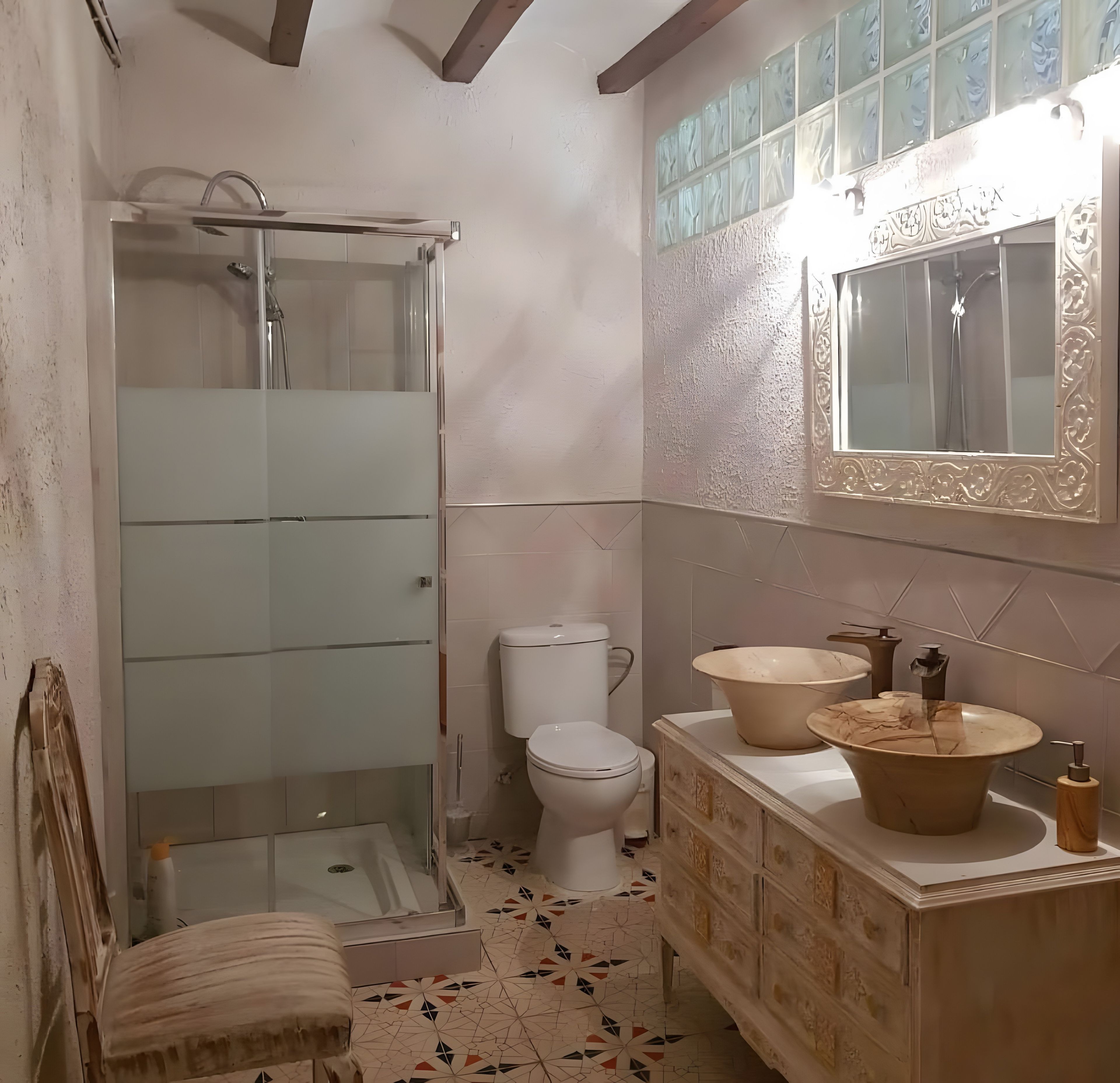 Une salle de bain avec une douche à parois de verre, des toilettes, un meuble-lavabo et un miroir.