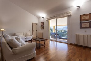 A spacious living room with a sofa, a coffee table, and a view of the outdoors through a large sliding glass door. - Villa 'Verdura' with Mountain View, Wi-Fi and Air Conditioning (Inca)