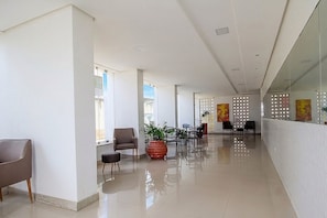 A spacious corridor with seating areas, potted plants, and artwork on the walls. - Apt. in Condo. w/ BBQ & Sea View Bvm0510 (Recife)