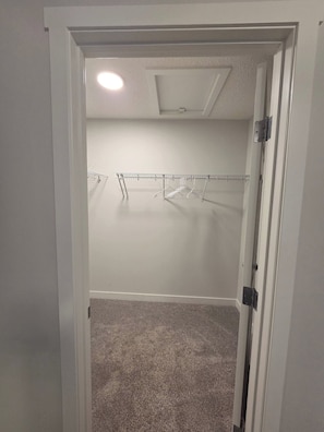 A walk-in closet with a metal drying rack and a carpeted floor. - Spacious Family House in Edmonton - Perfect for a Comfortable Stay (Edmonton)