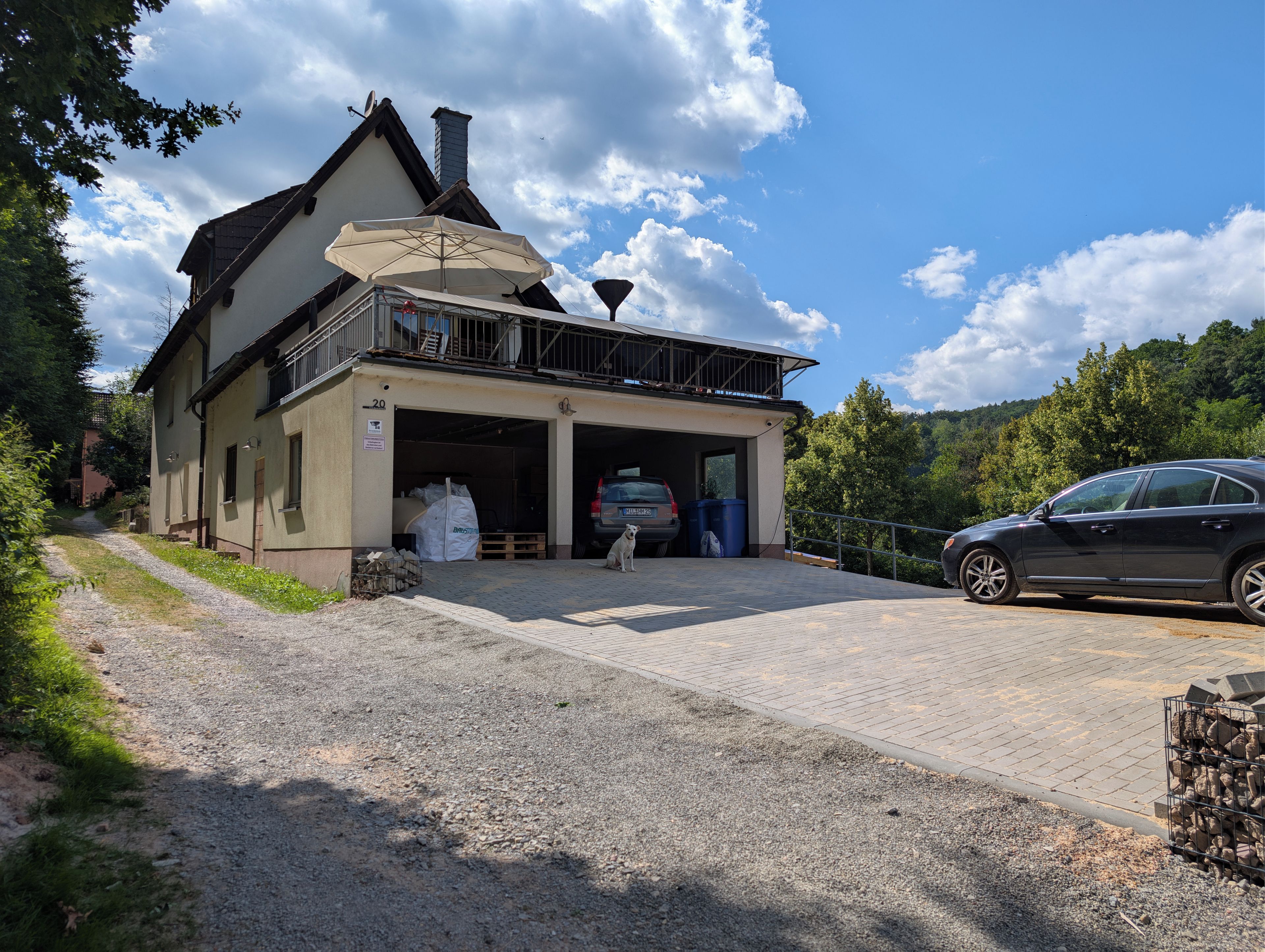 A two-story building with a covered entrance and a car parked in front.