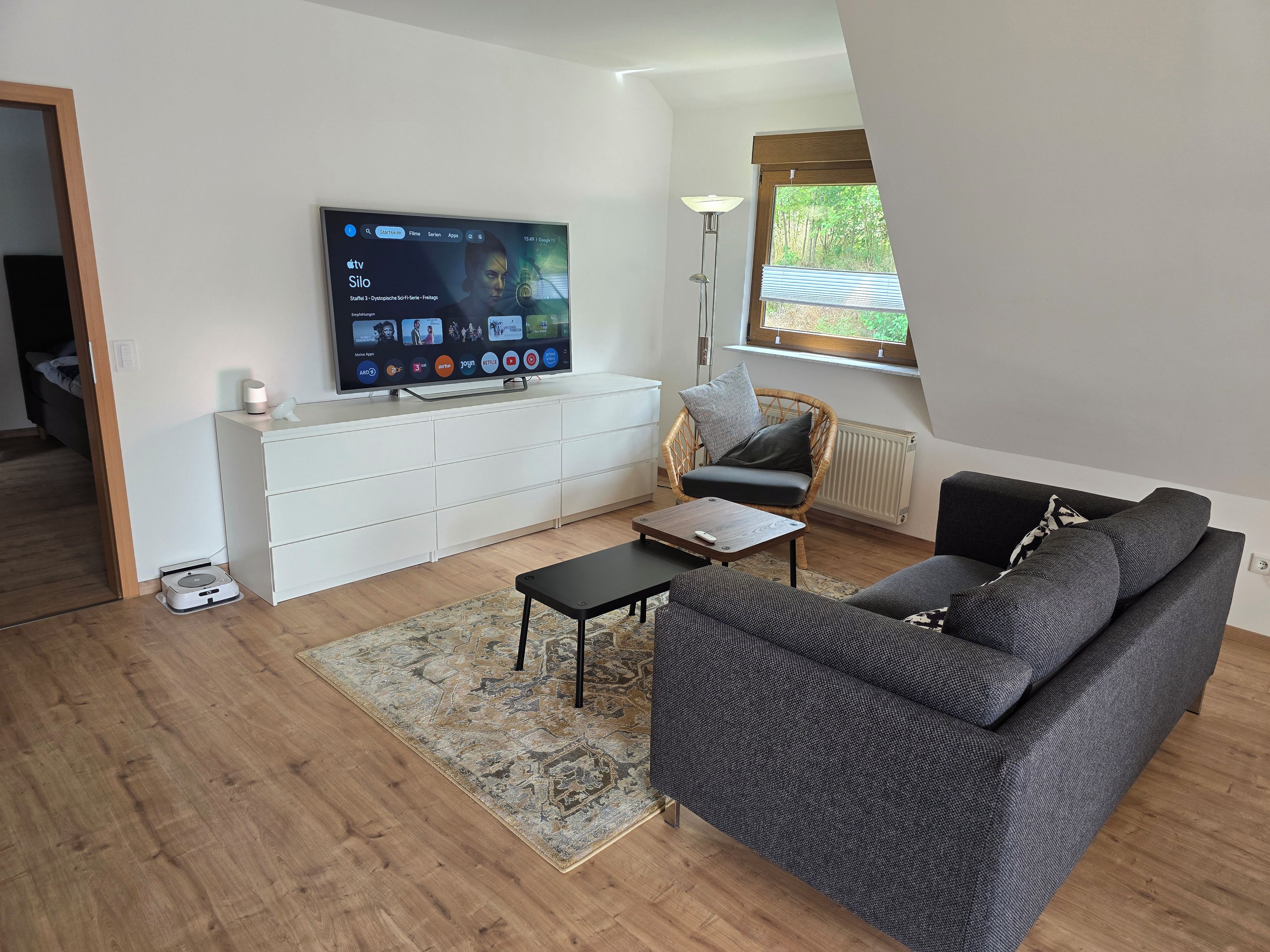 Wohnbereich mit großem Smart-TV und Soundbar