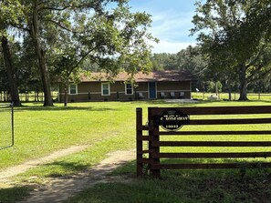 A park with a bench, a building with a sign, and a fenced area. - High Springs Hideaway / Country Charm & Wildlife (High Springs)
