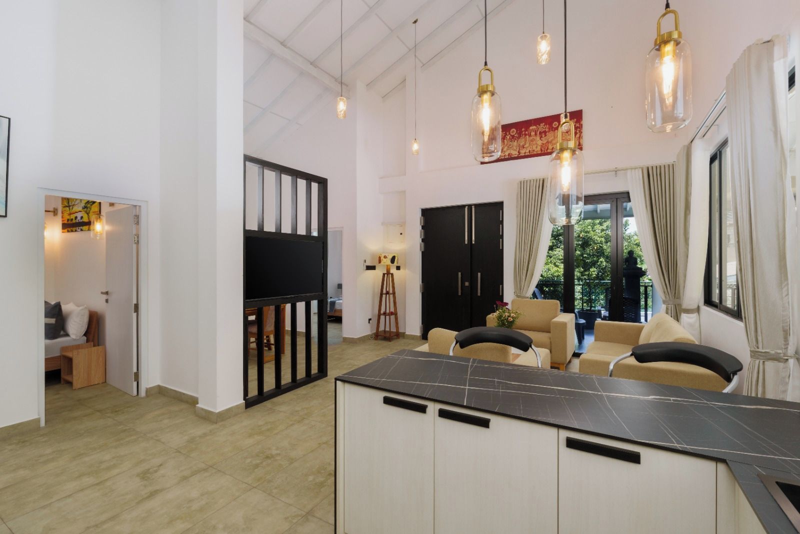 Ein modernes Interieur mit Kücheninsel, Essbereich und Blick ins Freie.