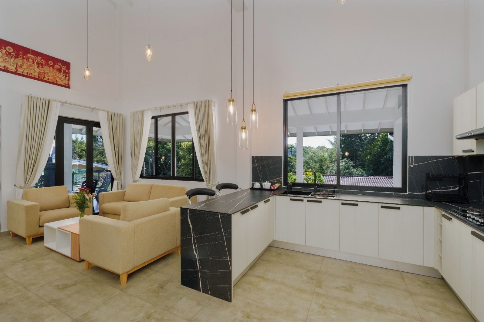 A modern kitchen with a black countertop, white cabinets, and a large window.