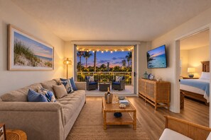 A living room with a sofa, coffee table, and a view of the outdoors. - Dunes Dream Just 100 Steps from the Beach (Jensen Beach)