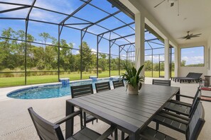 A covered outdoor area with a pool, seating, and a view of the surrounding landscape. - Luxury 15BR Suites, Pool and Themed Bedrooms (Williamsburg)