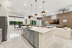 A modern kitchen with a central island, stainless steel appliances, and pendant lighting. - Luxury 15BR Suites, Pool and Themed Bedrooms (Williamsburg)
