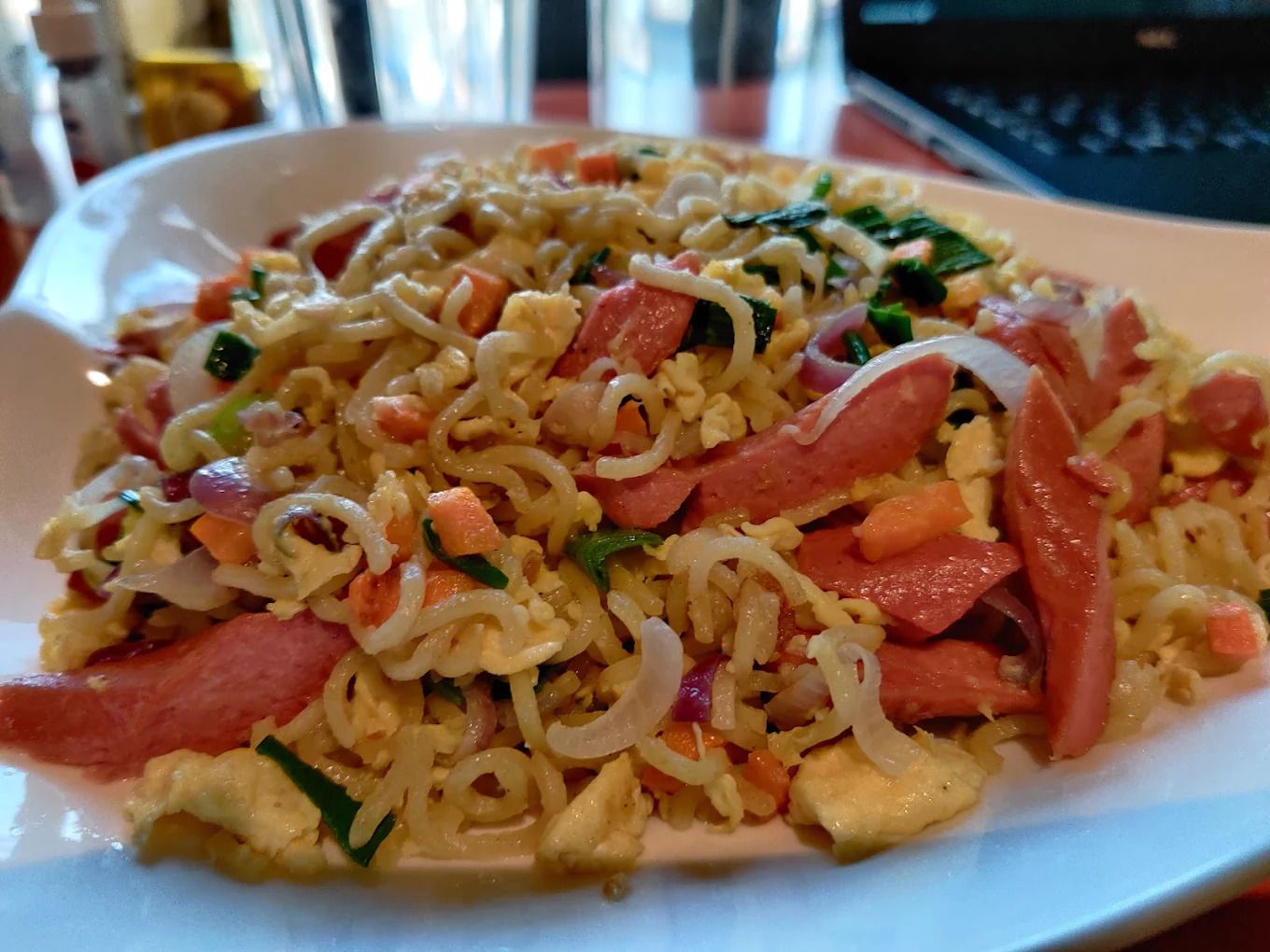 A plate of stir-fried noodles with vegetables and meat.