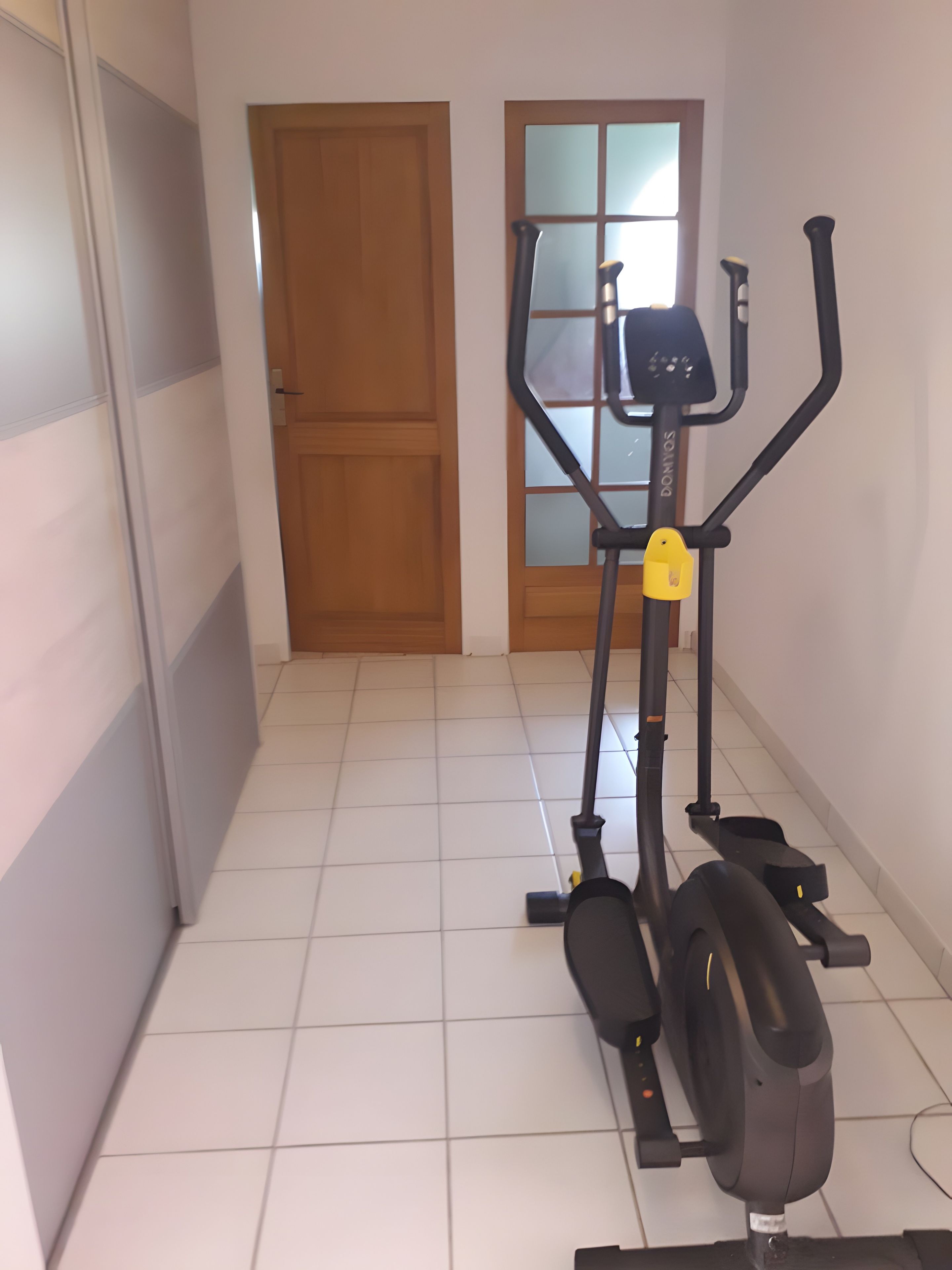 Ein Flur mit einem stillstehenden Fahrradtrainer und einer Tür.