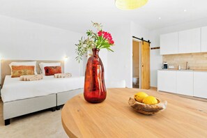 A modern bedroom with a bed, bedside table, and a vase with flowers. - Apartment for two among olive groves in Andalusia (Alcaucin)