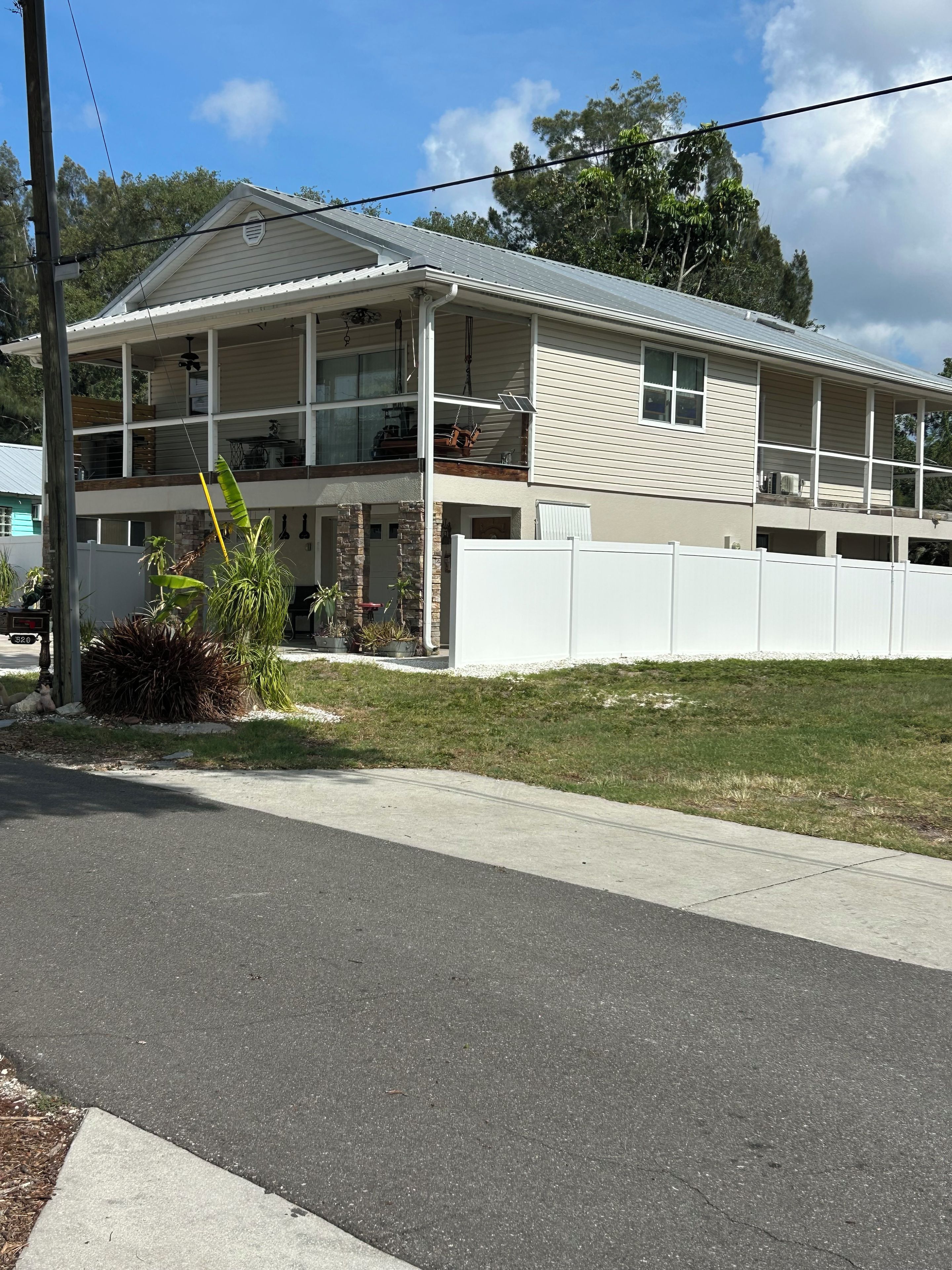 A two-story house with a garage, a covered front porch, and a fenced yard.