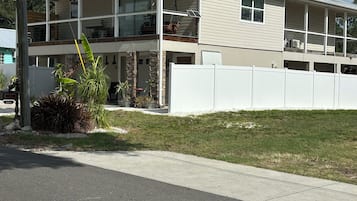 A two-story house with a garage, a covered front porch, and a fenced yard.