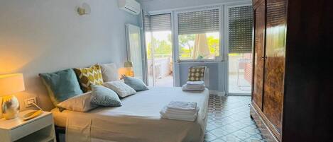 A bedroom with a bed, bedside table, and a wardrobe.