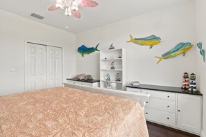 A bedroom with a bed, a wardrobe, a ceiling fan, and wall-mounted fish decorations. - Pet-Friendly Canal Retreat  Pool & Balconies (Bonita Springs)