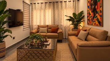 A living room with a sofa set, a coffee table, and a television.