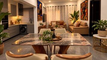 A modern living space with a dining area, kitchen, and seating area.