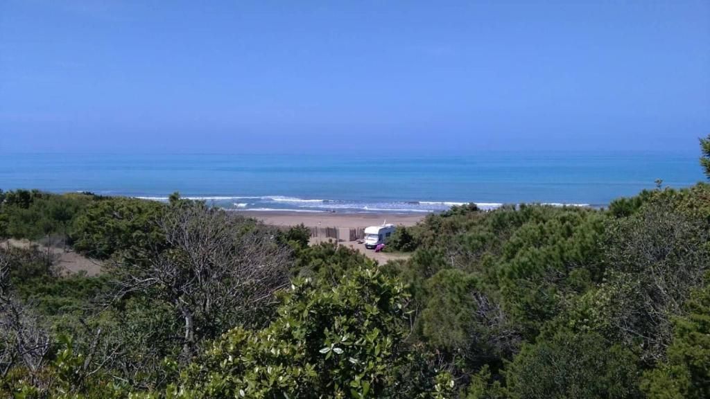 A beach view with a trailer in the foreground and a clear sky.