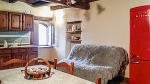 A kitchen with wooden cabinets, a red refrigerator, and a table with a basket of bread. - Domus Claudia - Castiglione in Teverina (Castiglione In Teverina)