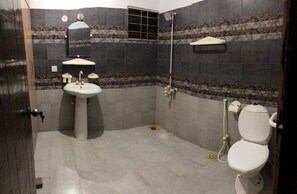 A bathroom with a sink, toilet, and shower.
