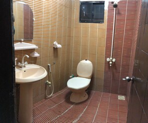 A small bathroom with a toilet, sink, and shower. - Feel Like Home in a Luxury, Secured and Peaceful 2 Story House (Karachi)