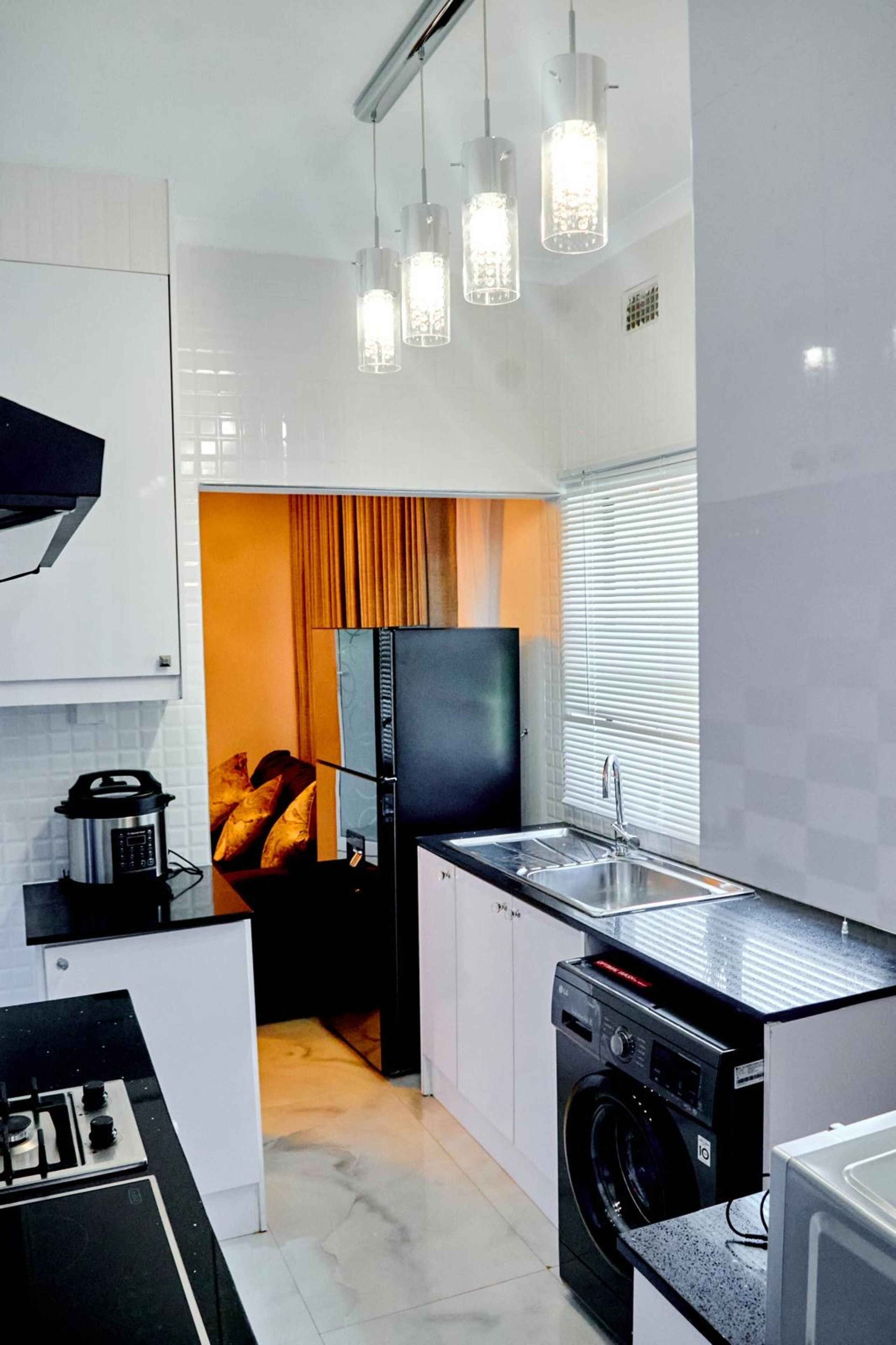Una cocina moderna con horno integrado, lavadora y pileta.