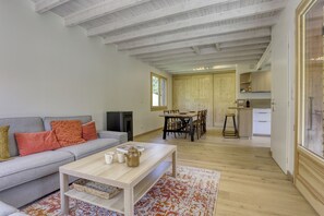 A modern living room with a grey sofa, a wooden coffee table, and a patterned rug. - Jacques’s Treasure: A cosy, renovated chalet in the Chartreuse (Saint-Pierre-d'Entremont)