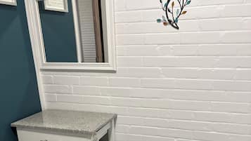 A bathroom with a white vanity, a toilet, and a blue-striped floor.