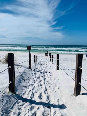 A sandy beach with a wooden fence leading to the ocean. - St. Somewhere (Panama City Beach)