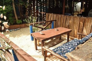 An outdoor seating area with a wooden table and a woven bench. - Triple bedroom with breakfast Kendwa. (Kendwa,)