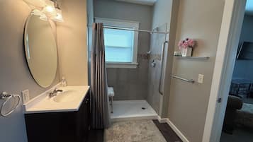 Ein Badezimmer mit Dusche, Toilette, Waschbecken und Spiegel.