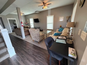 A living room with a sofa, armchairs, a coffee table, and a television. - 2 Bedroom, main floor room with private entrance (Fairbury)