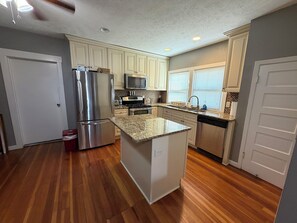 A kitchen with a refrigerator, microwave, stove, and sink. - 1 Bedroom Unit with Full Size Bed (Fairbury)