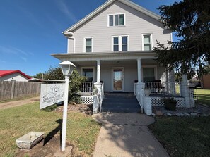 A two-story house with a porch, a sign for Grayhouse Inn, and a mailbox.