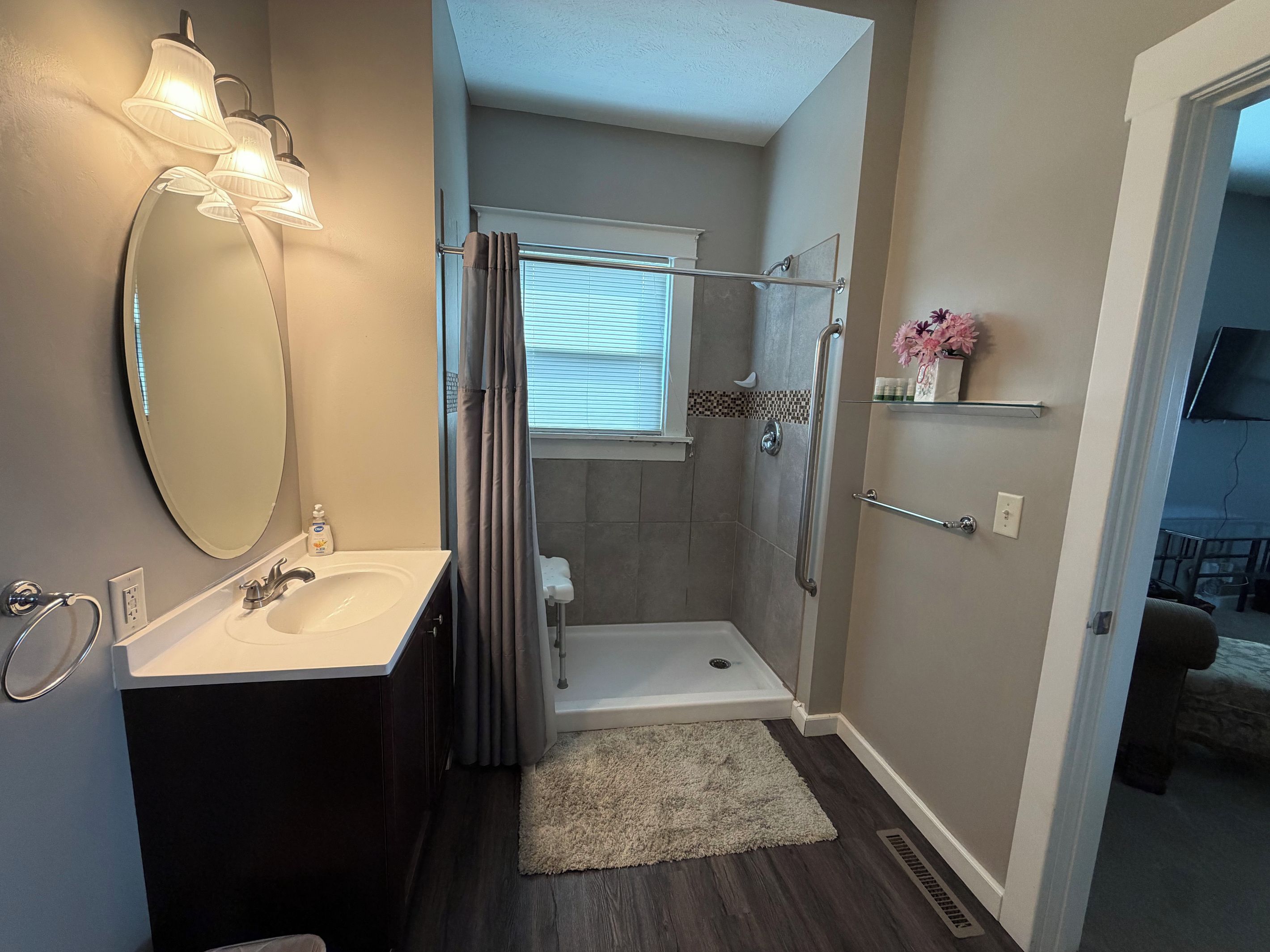 A bathroom with a shower, a toilet, a sink, and a mirror.
