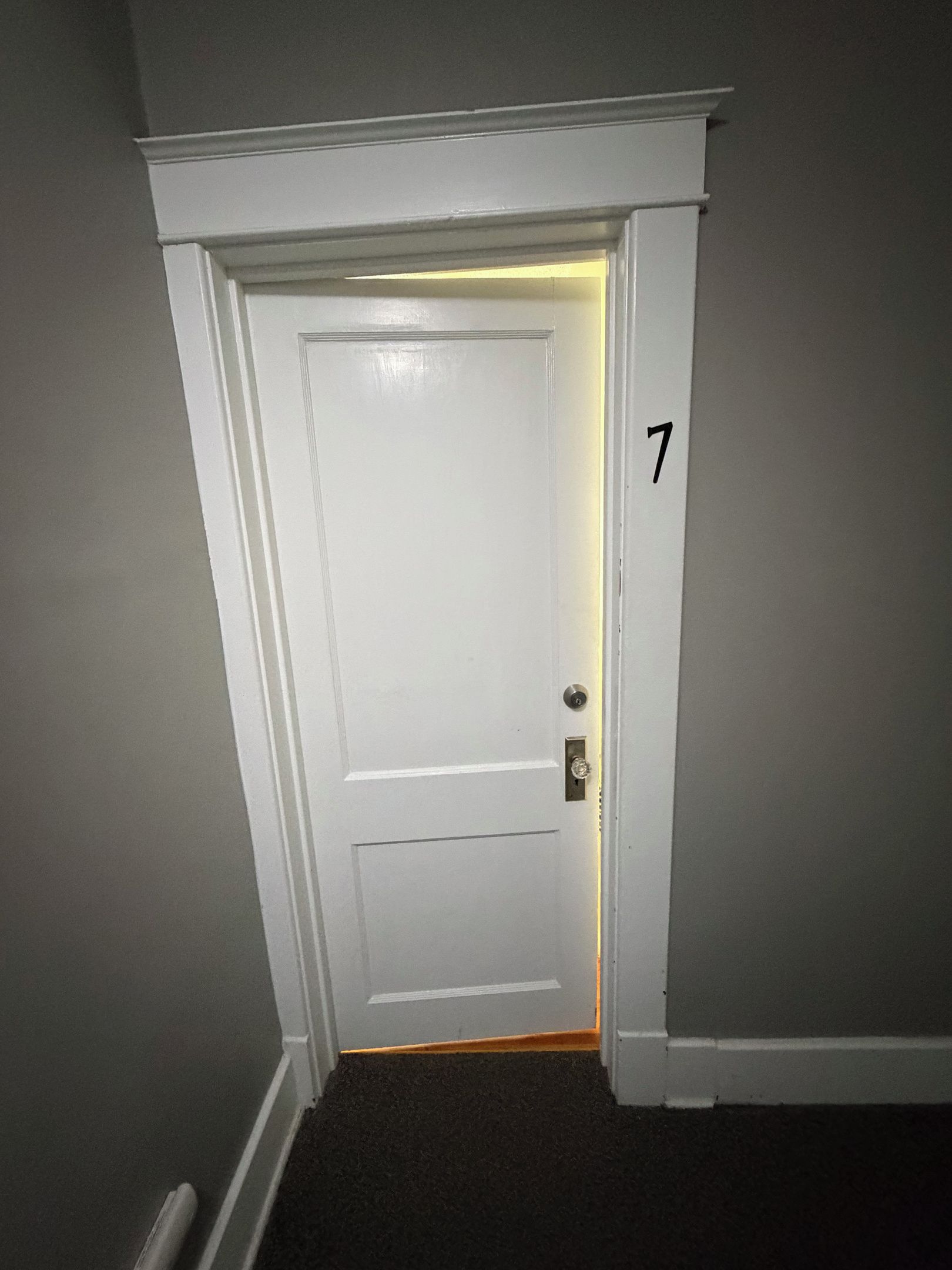 A white door with a number '7' on the wall beside it.