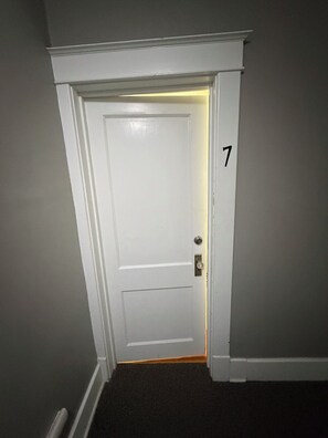 A white door with a number '7' on the wall beside it.