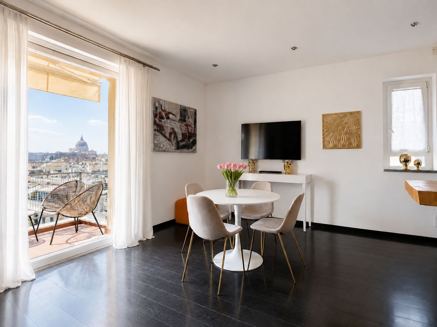 A modern living room with a dining area, a flat-screen TV, and artwork on the walls.