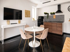 A modern kitchen with a black stove, white cabinets, and a black and white patterned backsplash. - Vatican Sky view Spa Apartment by RHR (ROMA)