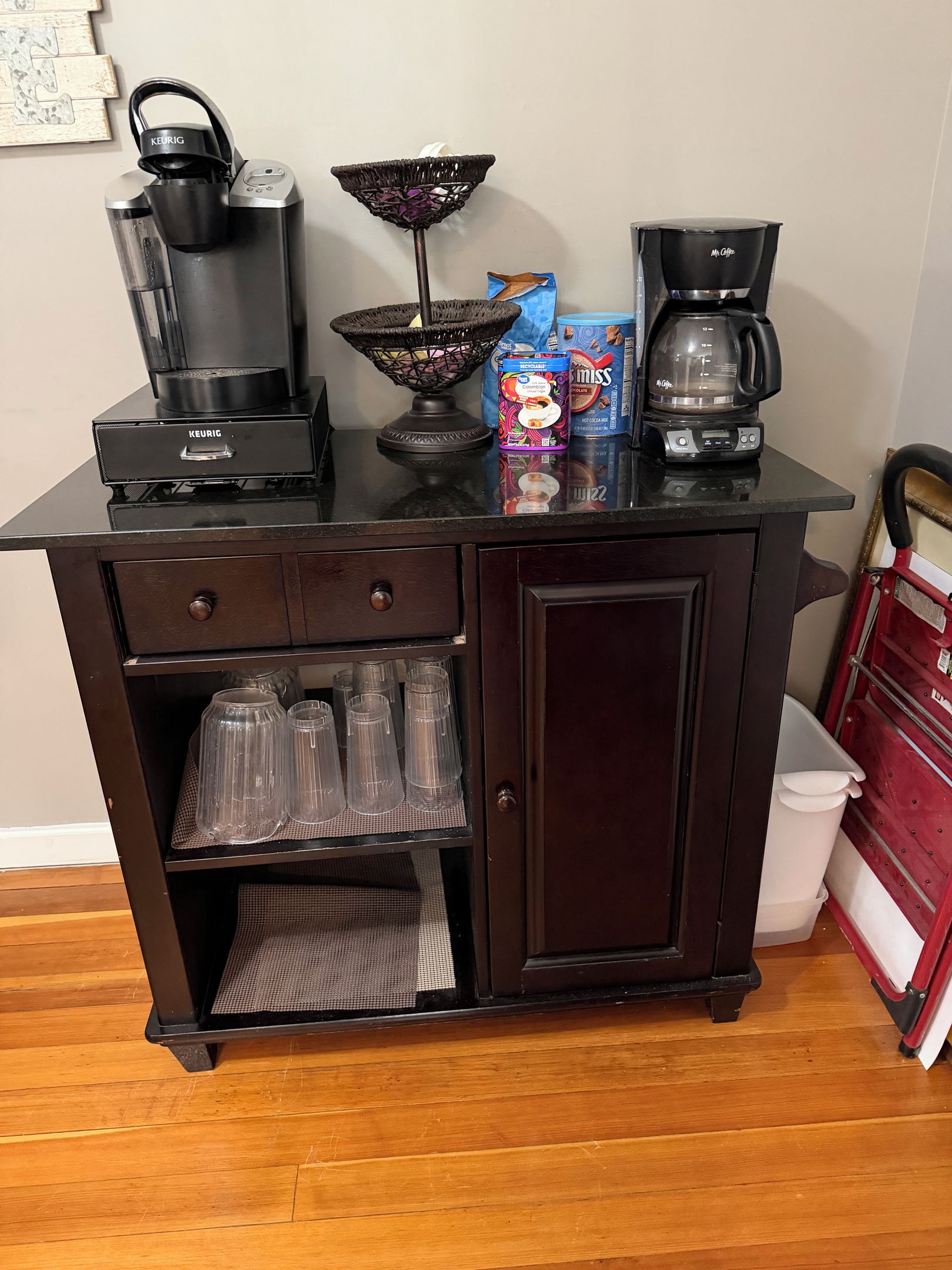 Una kitchenette con cafetera, máquina Keurig, una cesta y una caja de McFlurry.
