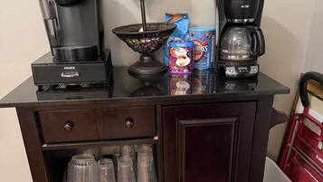 Una kitchenette con cafetera, máquina Keurig, una cesta y una caja de McFlurry.