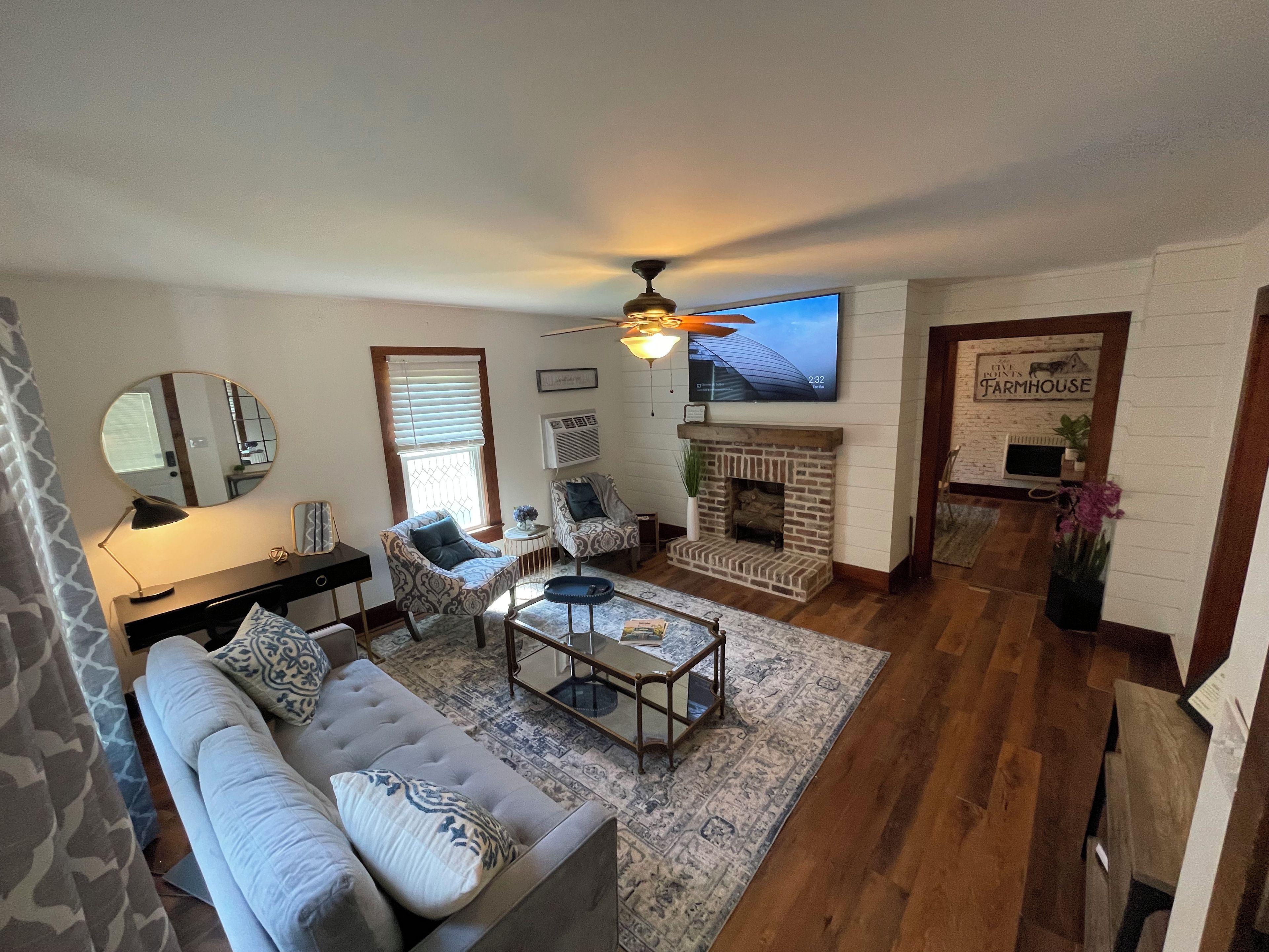 A living room with a fireplace, a sofa, a coffee table, and a television.
